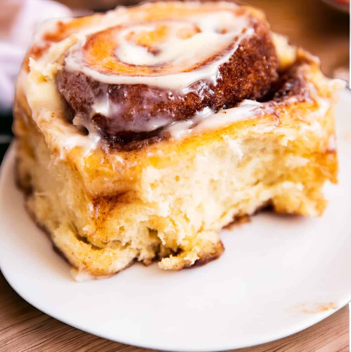 Single Sticky Bun served on a plate accompanied by a fork