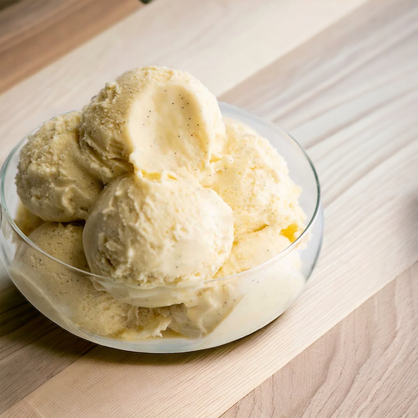 Vanilla ice cream served in a bowl on a wooden surface