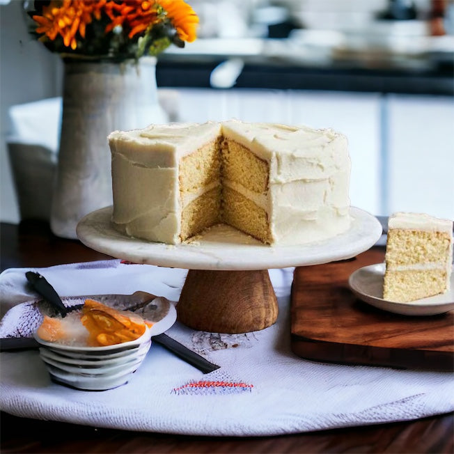 Vanilla-flavored cake displayed on a stand with a serving knife beside it